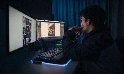 man in black hoodie sitting in front of computer