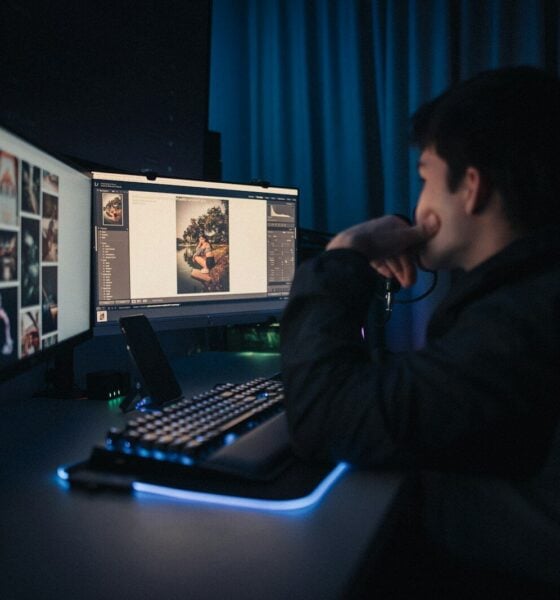 man in black hoodie sitting in front of computer