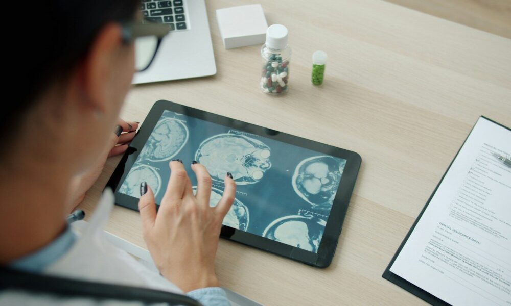 Doctor examining mri scans on a tablet screen