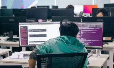 a man sitting in front of two computer monitors
