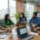 Five colleagues collaborating around a table in a modern office